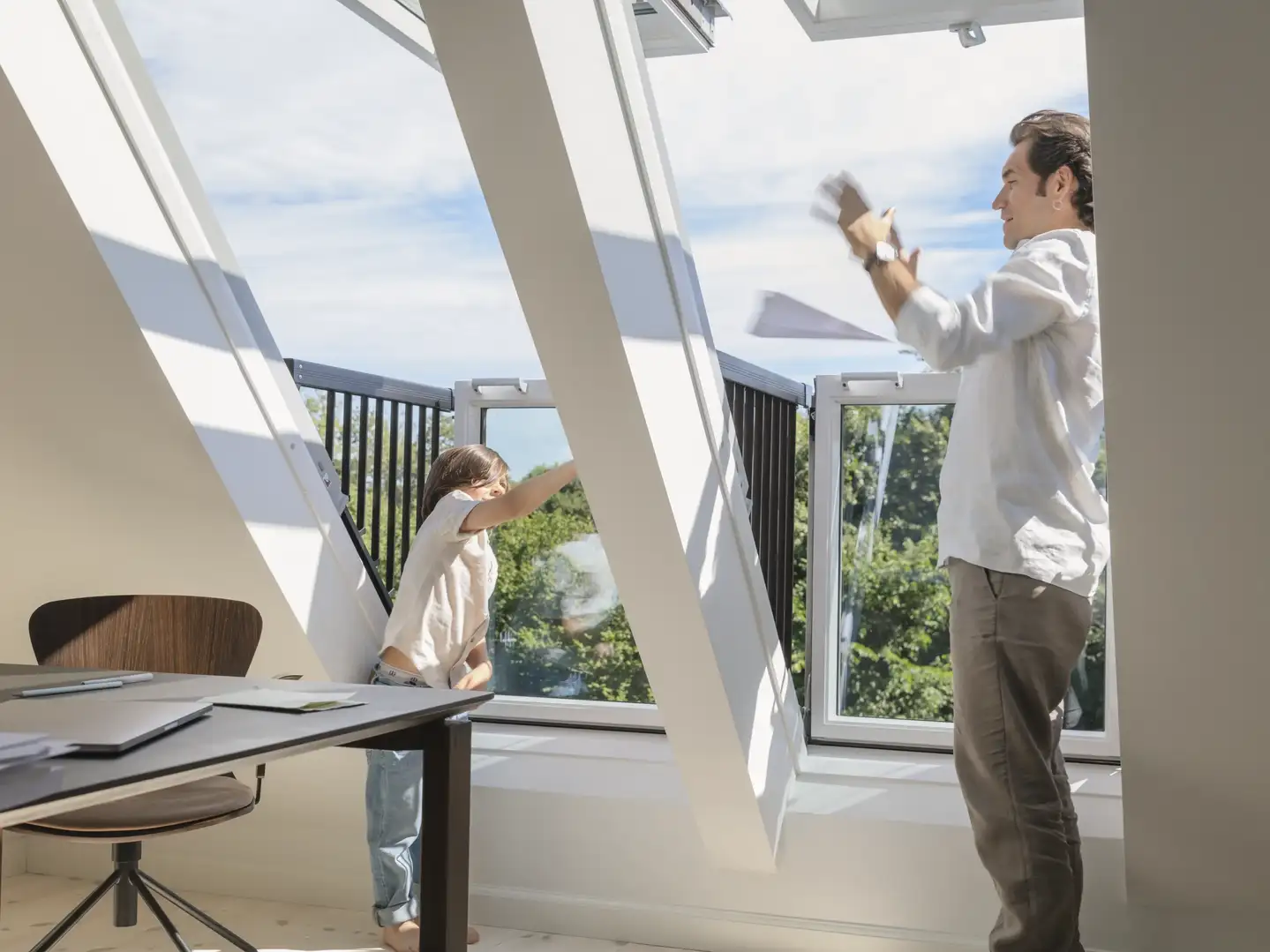 Famille profitant d'un double balcon Velux dans une maison